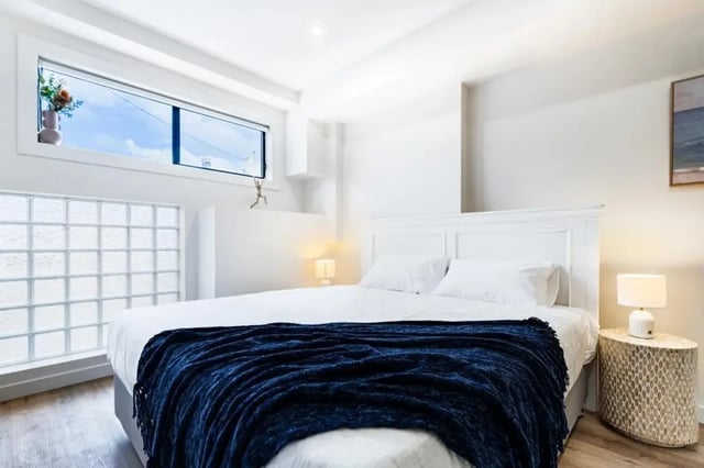 White bed with navy throw glass blocks bedroom at UKO Annandale Tower C in Sydney Student Accommodation