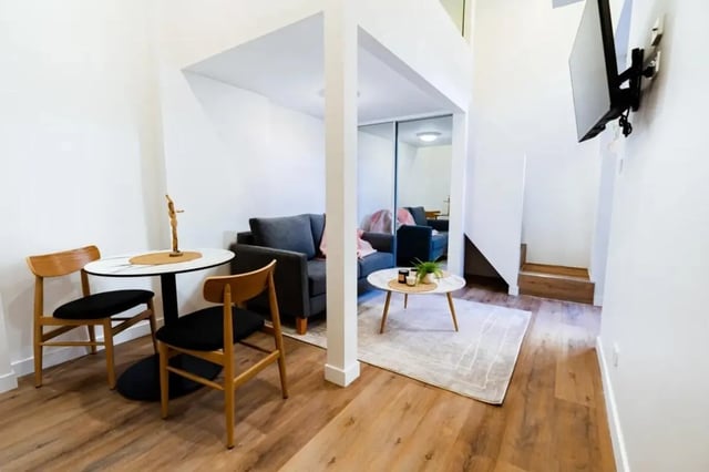 Table chairs couch rug and TV living room at UKO Annandale Tower C in Sydney Student Accommodation