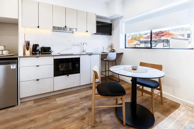 Modern kitchen with oven microwave and dining table kitchen at UKO Annandale Tower C in Sydney Student Accommodation
