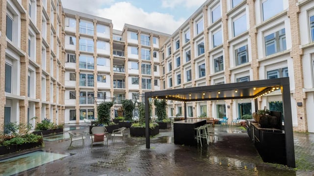 Courtyard seating bar area with planters exterior at Wick Park in London Student Accommodation