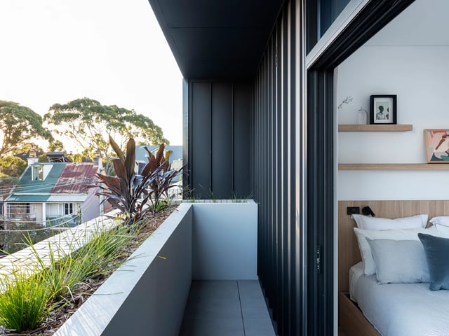 Balcony plants outside bedroom with bed and shelves Bedroom at UKO Glebe in Sydney Student Accommodation