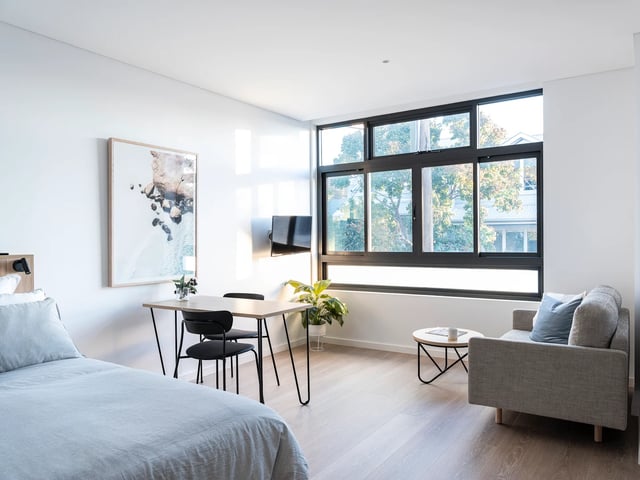 Bed table chairs TV sofa artwork interior living room at UKO Glebe in Sydney Student Accommodation