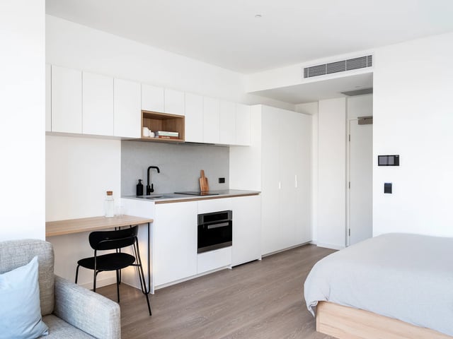 Compact kitchen with desk and bed studio apartment at UKO Glebe in Sydney Student Accommodation