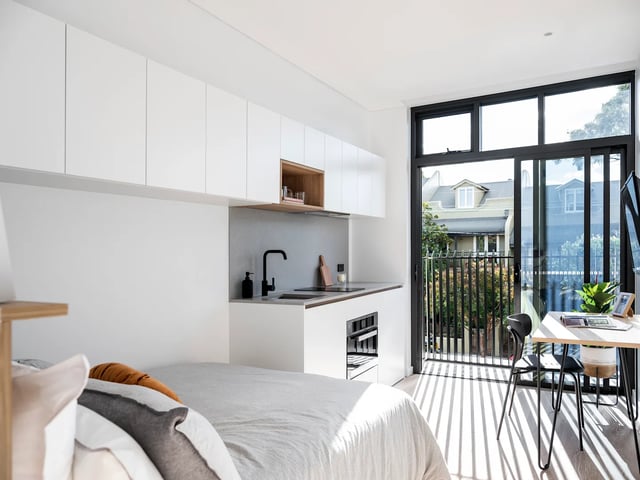 Bed kitchen study area with balcony exterior at UKO Glebe in Sydney Student Accommodation