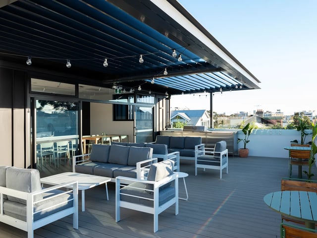Outdoor lounge area with sofas chairs tables exterior at UKO Glebe in Sydney Student Accommodation