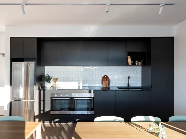 Modern black kitchen with stainless steel refrigerator kitchen at UKO Glebe in Sydney Student Accommodation