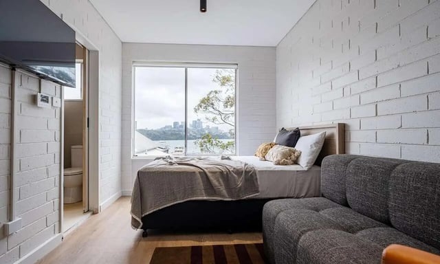 Bed couch and toilet visible bedroom at UKO Balmain in Sydney Student Accommodation