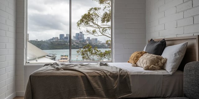 Bed with cityscape view and pillows bedroom at UKO Balmain in Sydney Student Accommodation