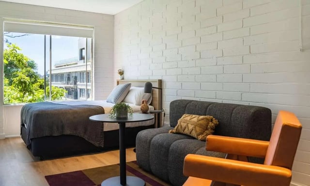 Bed sofa chair and round table living room at UKO Balmain in Sydney Student Accommodation