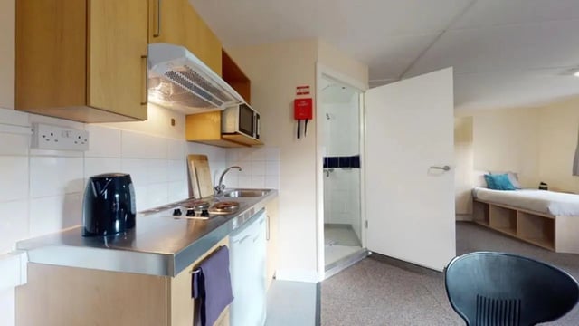 Kitchenette with sink hob microwave and bed bedroom at Creek Court in London Student Accommodation