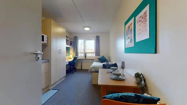 Desk bed cabinets and microwave student studio bedroom at Creek Court in London Student Accommodation