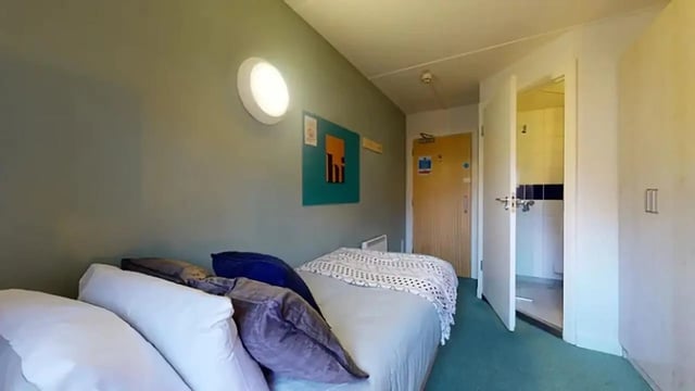 Bed pillows and blanket open door bathroom Bedroom at Creek Court in London Student Accommodation