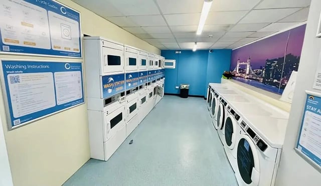 Row of washing machines and dryers laundry room at Creek Court in London Student Accommodation