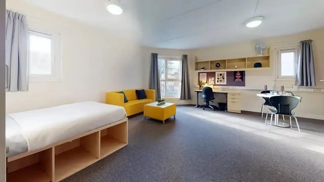 Bed sofa desk and dining area living room at Creek Court in London Student Accommodation