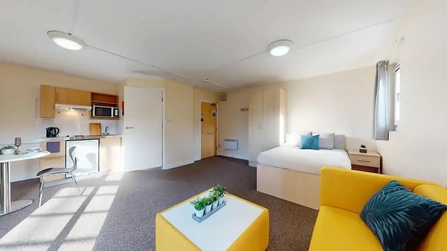 Kitchen bed yellow sofa living area student studio at Creek Court in London Student Accommodation