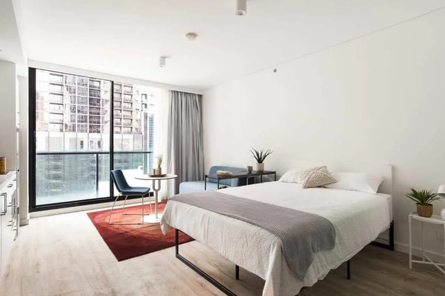 Bed table chair sofa plants window bedroom at UKO Melbourne Central in Melbourne Student Accommodation