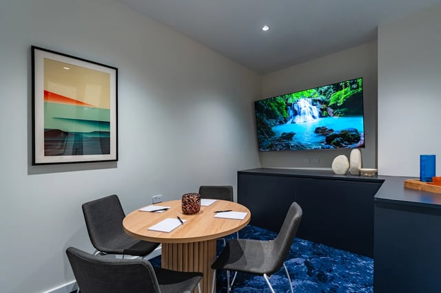 Round table chairs artwork and TV living room at UKO Melbourne Central in Melbourne Student Accommodation