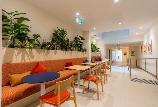 Orange couch with tables and chairs communal area at UKO Melbourne Central in Melbourne Student Accommodation
