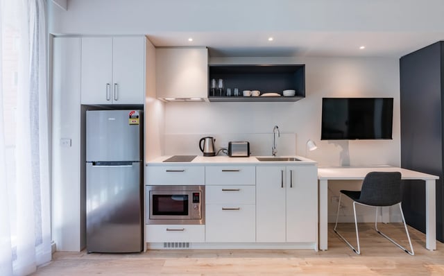 Compact kitchen with fridge microwave sink and television kitchen at UKO Melbourne Central in Melbourne Student Accommodation