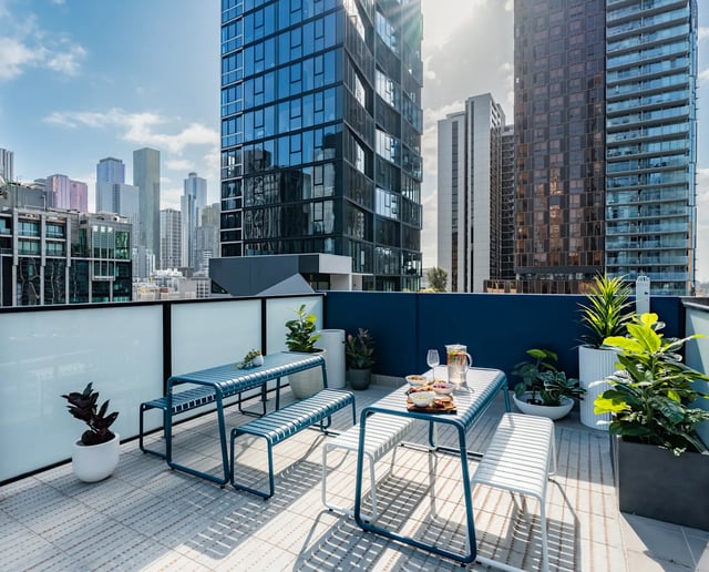 Blue tables and benches on outdoor terrace exterior at UKO Melbourne Central in Melbourne Student Accommodation
