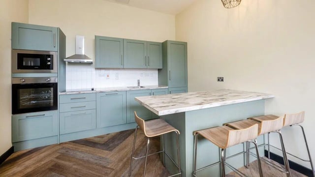 Kitchen with grey cabinets island and stools kitchen at Fontenoy Apartments in Liverpool Student Accommodation