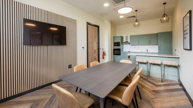 Large table with chairs and kitchen communal area at Fontenoy Apartments in Liverpool Student Accommodation