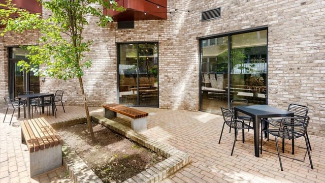 Tables chairs benches with tree courtyard exterior at Fontenoy Apartments in Liverpool Student Accommodation