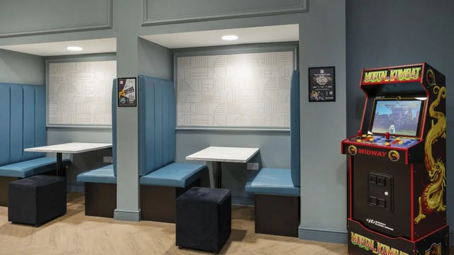 Booth seating tables and arcade machine lounge area at 26 Great George Street in Leeds Student Accommodation