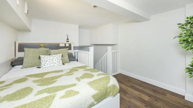 Bed with green pillows and patterned throw Bedroom at 26 Great George Street in Leeds Student Accommodation