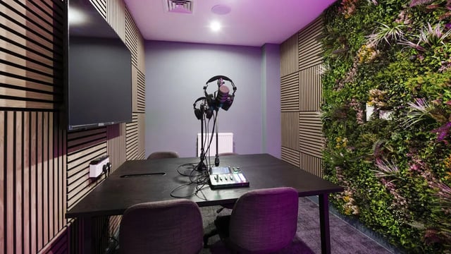 Podcast studio with microphones table chairs and foliage wall Studio at 26 Great George Street in Leeds Student Accommodation