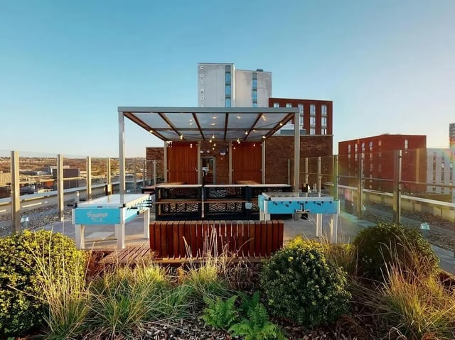 Foosball tables under pergola with seating playing area at COSMOS in Sheffield Student Accommodation