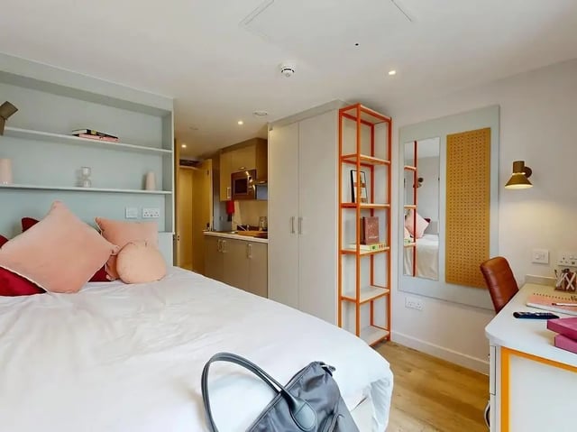 Bed kitchen area with desk and shelves bedroom at COSMOS in Sheffield Student Accommodation