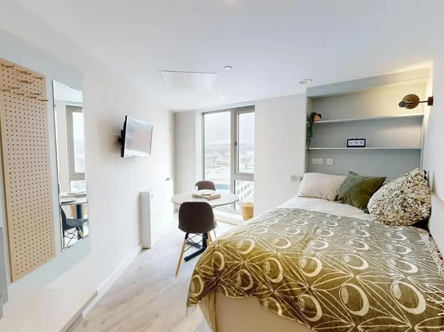 Bed table television and shelving unit bedroom at COSMOS in Sheffield Student Accommodation