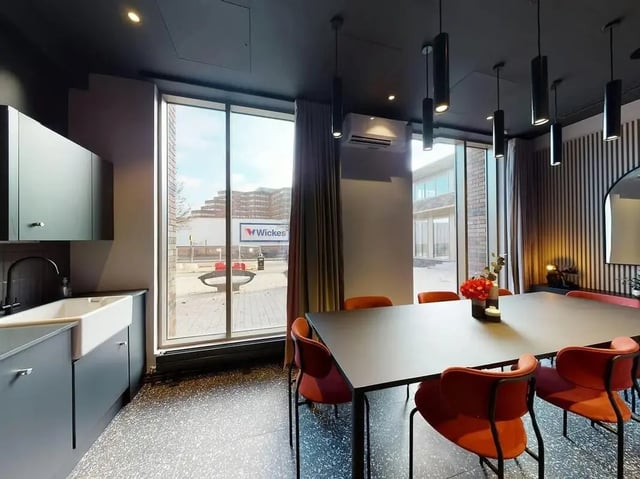Kitchen table with orange chairs living area at COSMOS in Sheffield Student Accommodation