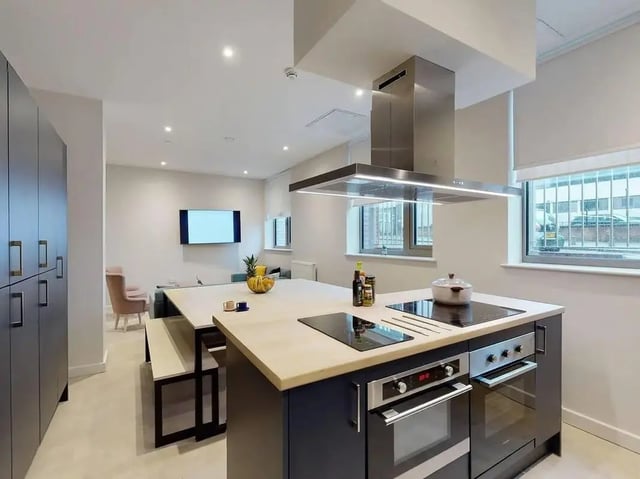 Modern kitchen island with stove and cabinets kitchen at COSMOS in Sheffield Student Accommodation
