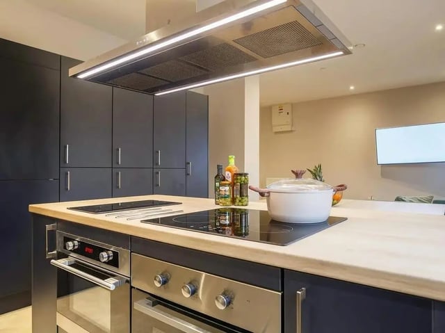 Modern kitchen island with cooktop pots and cabinets kitchen at COSMOS in Sheffield Student Accommodation