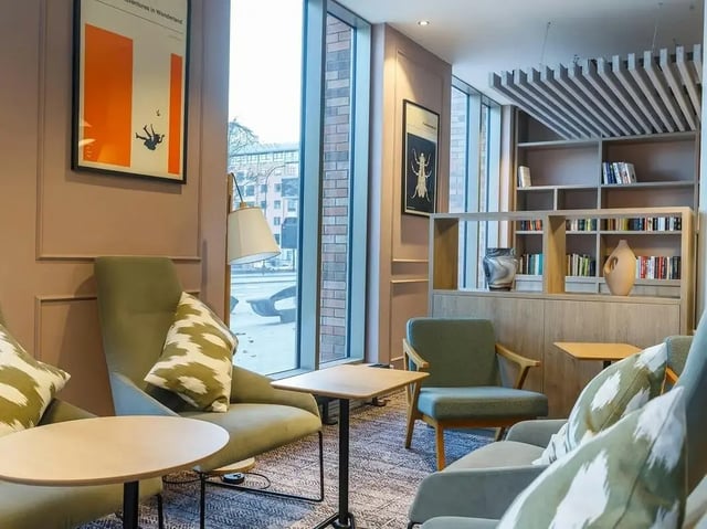 Chairs tables and bookshelves in common area at COSMOS in Sheffield Student Accommodation
