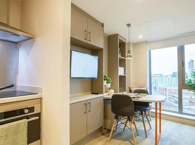 Modern studio kitchen with dining area and TV living room at COSMOS in Sheffield Student Accommodation