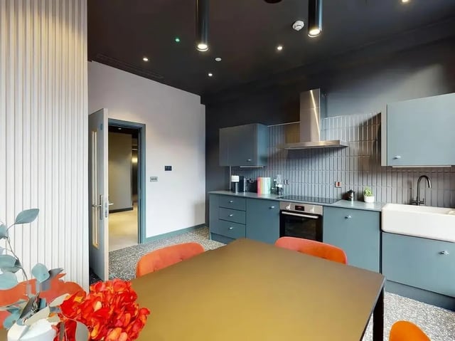 Modern kitchen with blue cabinets sink and table kitchen at COSMOS in Sheffield Student Accommodation