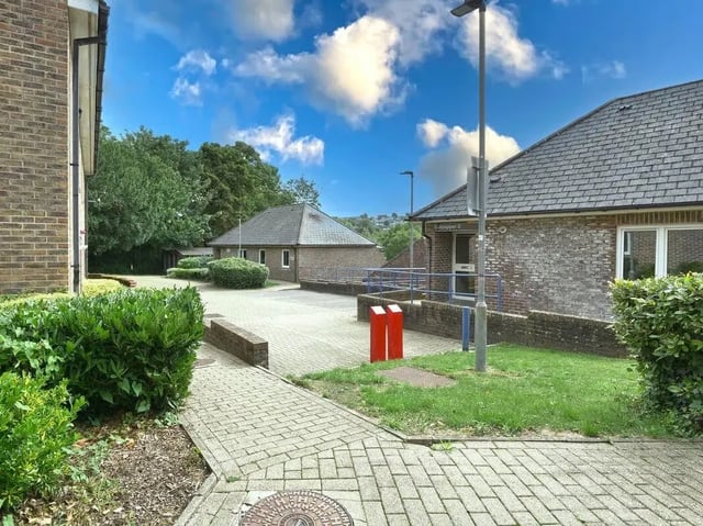 Brick buildings with paved paths and greenery exterior at Moulsecoomb Place in Brighton Student Accommodation