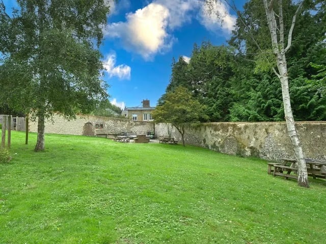 Picnic tables on lawn exterior building. at Moulsecoomb Place in Brighton Student Accommodation