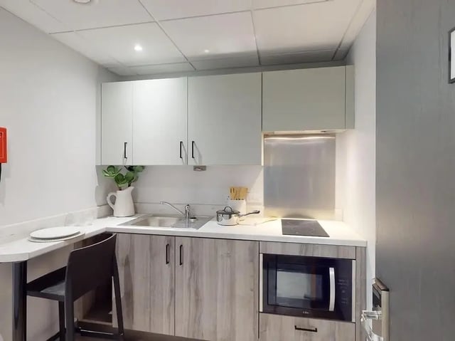 Sink microwave cabinets and stovetop kitchen at Crown Place Swansea in Swansea Student Accommodation