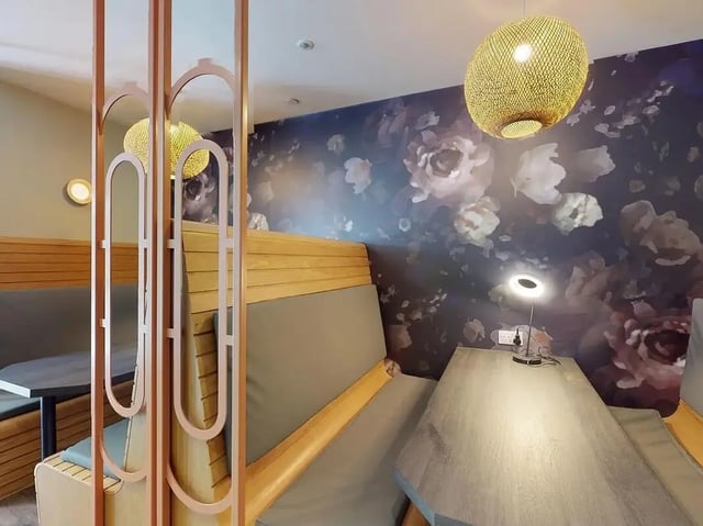 Booths with tables and floral wallpaper common area at Crown Place Swansea in Swansea Student Accommodation