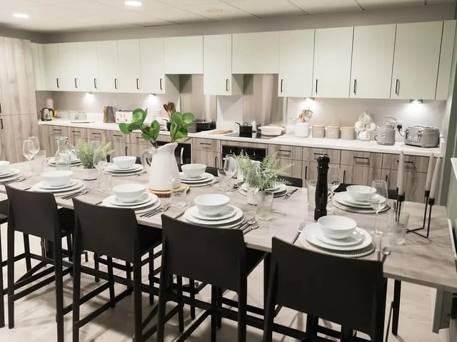 Dining table set with plates and chairs kitchen at Crown Place Swansea in Swansea Student Accommodation