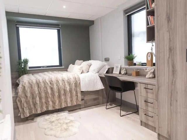 Bed with fluffy blanket desk chair bookcase Bedroom at Crown Place Swansea in Swansea Student Accommodation