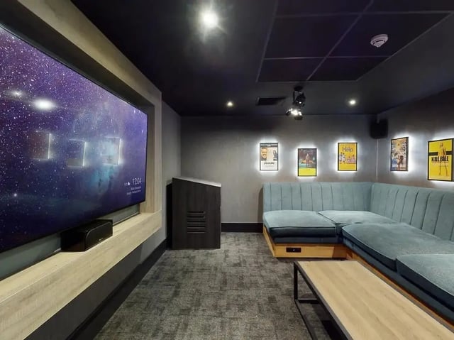 Large television blue sectional couch movie posters living room at Crown Place Swansea in Swansea Student Accommodation