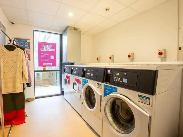 Washing machines with clothes rack laundry room at Elmstead Place in Colchester Student Accommodation