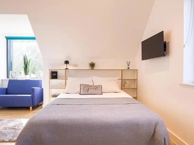Bed blue sofa framed photos bedroom at Elmstead Place in Colchester Student Accommodation