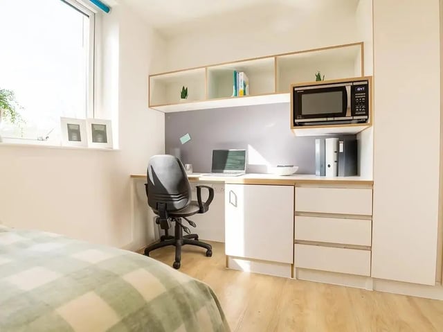 Desk chair microwave laptop and shelves study area at Elmstead Place in Colchester Student Accommodation