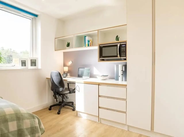 Desk chair laptop microwave and shelves study area at Elmstead Place in Colchester Student Accommodation